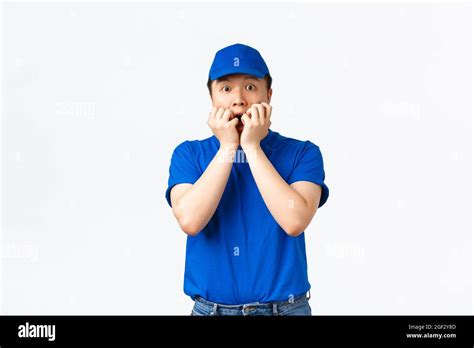 Portrait Of Startled Frightened Asian Delivery Man Gasping Holding