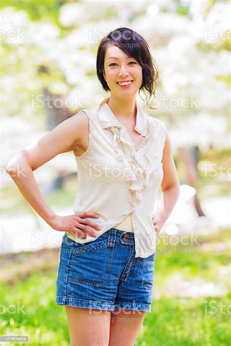 beautiful active healthy mature japanese woman in park portrait stock