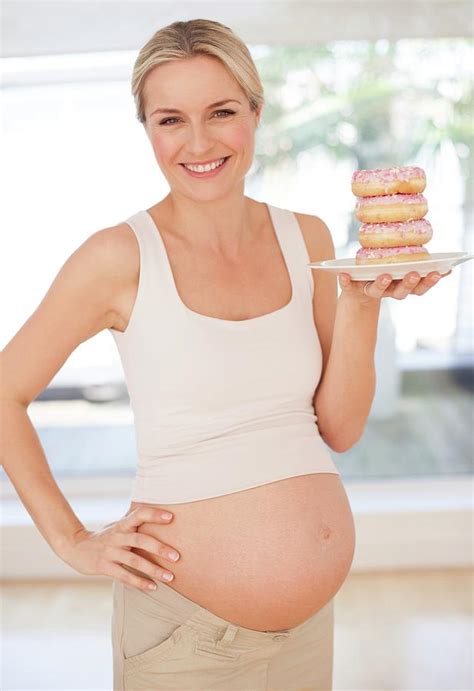 pregnant woman with doughnuts photograph by ian hooton science photo
