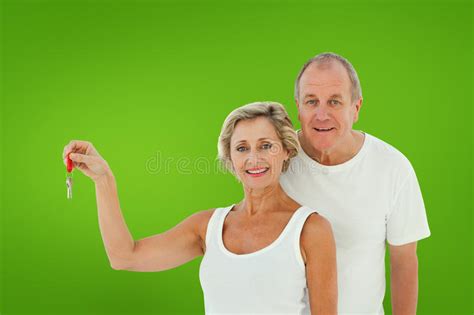 Composite Image Of Mature Couple Smiling At Camera With New House Key
