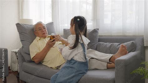 Granddaughter Brought Medicine And Water Drink For Grandpa On The Sofa