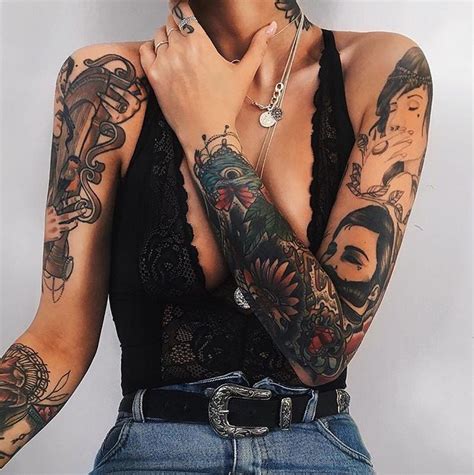 A Woman With Many Tattoos On Her Arms