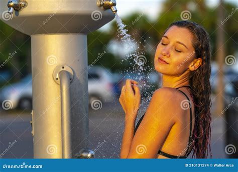 A Lovely Brunette Model Showers Outdoors After Swimming In The Ocean