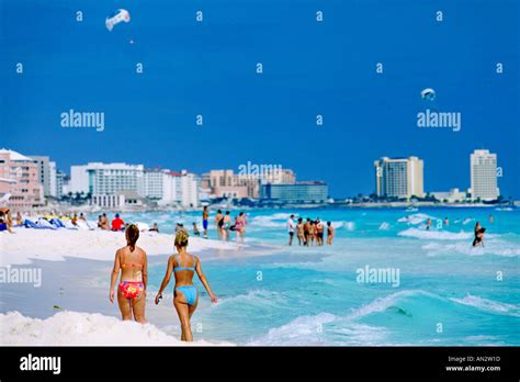 Two Bikini Clad Women Walking On The Cancun Beach On Mexicos Caribbean