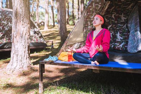 giovane asiatica che fa yoga mentre  accampa nella foresta immagine