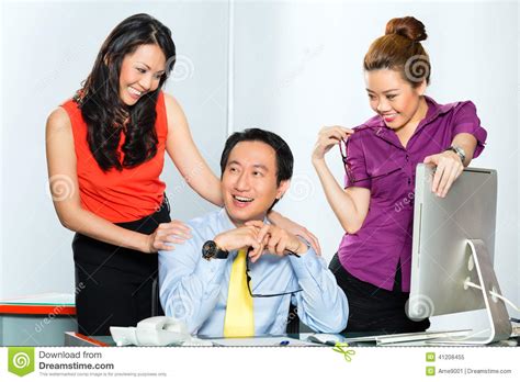 asian womanizer boss flirting at the office stock image