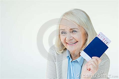 portrait of smiling senior woman showing passports and tickets stock