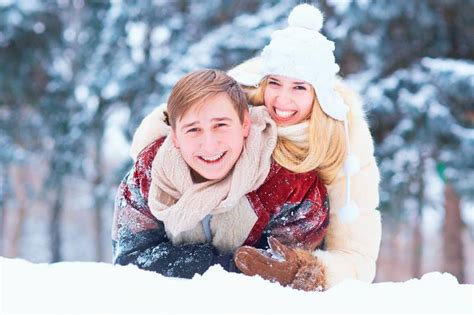 Portrait Of A Couple Laughing In The Snow In A Winter Park