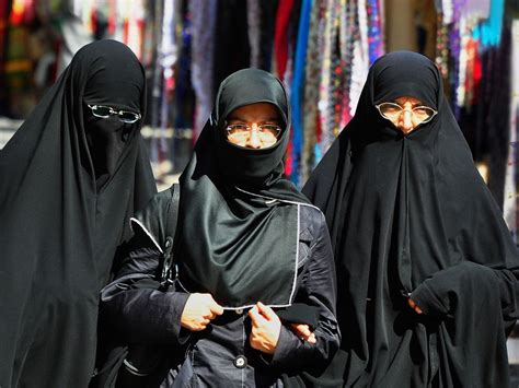 three radical muslim women black closed dressed are walking on the