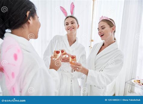 cheerful girls celebrating  toasting  spa salon stock photo