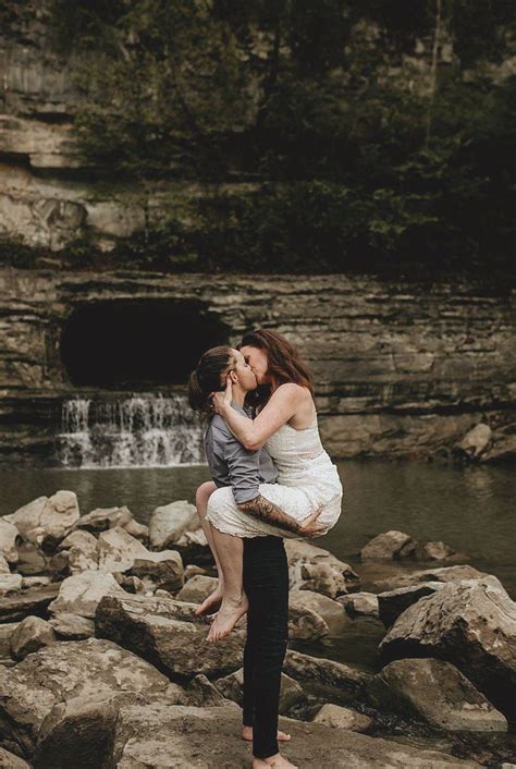 lesbian engagement photo kissing on cliffs and waterfall frolics in