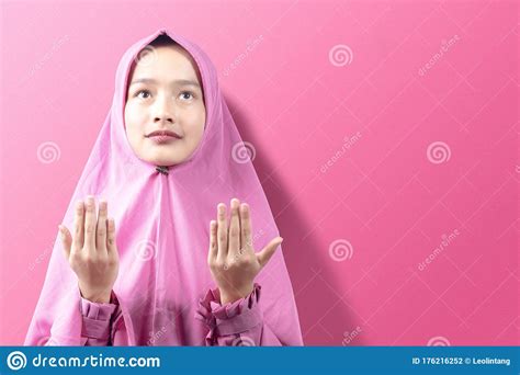 Asian Muslim Woman In A Veil Standing While Raised Hands