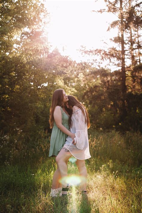 lesbian couple romancing in forest during summer photograph by cavan