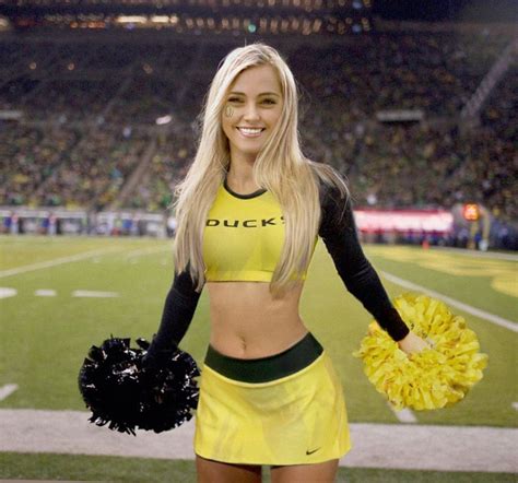 a woman in a yellow and black uniform holding a cheerleader s pom pom