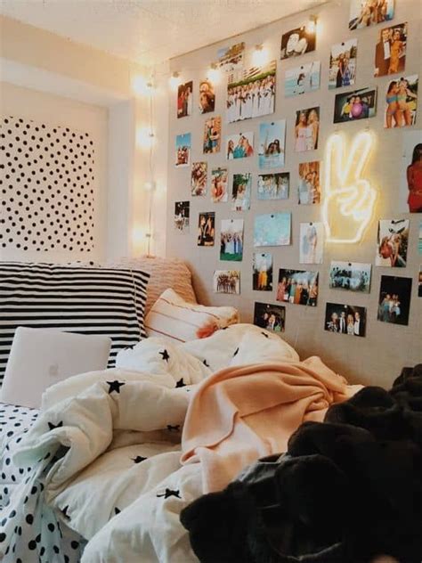 An Unmade Bed With Many Pictures On The Wall Above It And Lights