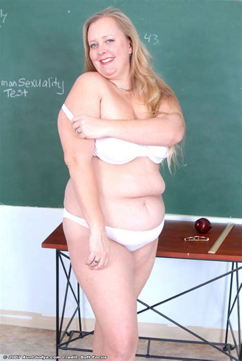 glassed plump mature teacher stripping in the classroom