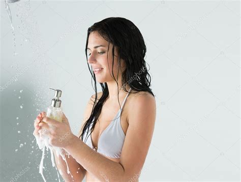 beautiful girl showering holding glass bottle with shower gel — stock
