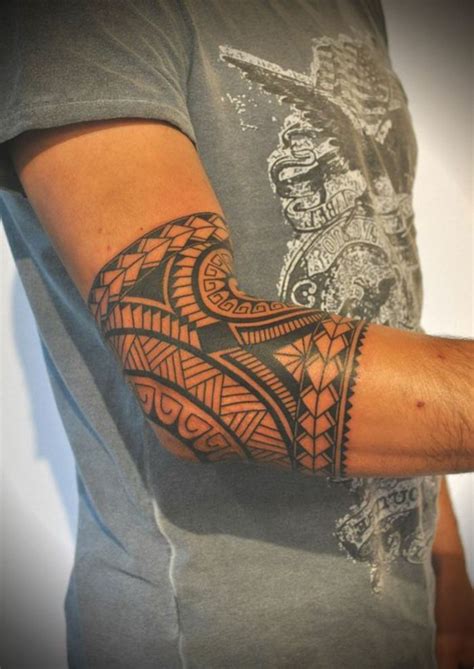 tatuajes maories hombre con camiseta gris tatuaje en brazo y codo brazalete polinesio con