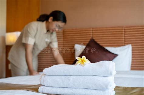 A Hotel Maid Stacked Towels On The Bed And Placed Flowers On The Towels