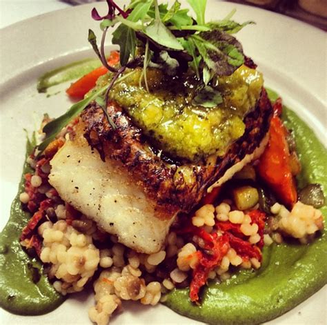 Seared Chilean Sea Bass Served On Top Of Sun Dried Tomato Cous Cous And