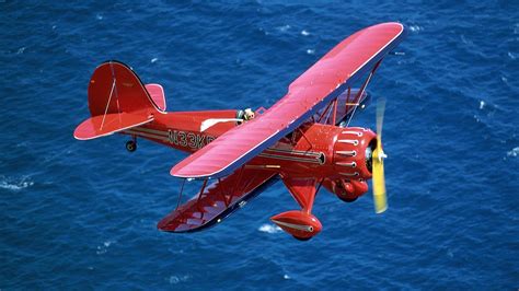 red airplane flying   blue sea wallpaper