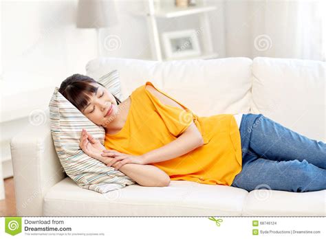 Happy Asian Teenage Girl Sleeping On Sofa At Home Stock