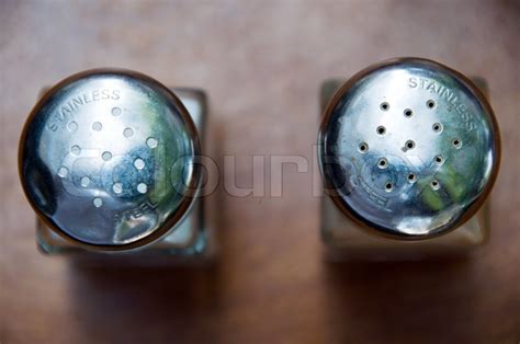 top view on salt and pepper shakers with stainless steel imprint being placed on wooden table