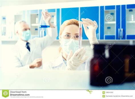 mature lady examining test tube in lab stock image image