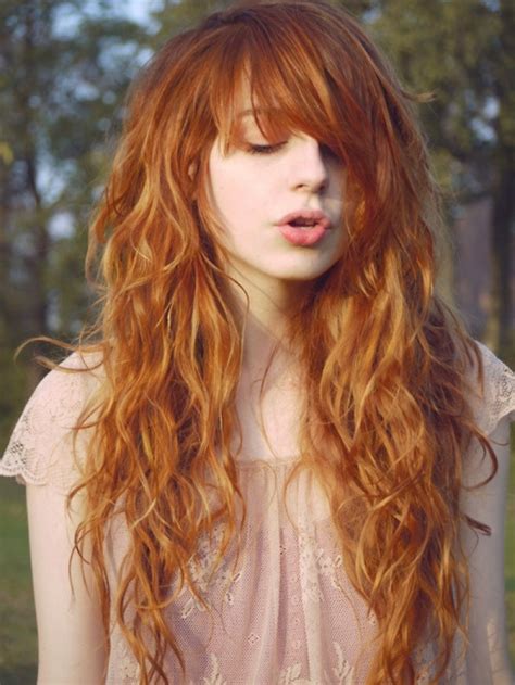 long wavy ginger hair with a lot of curls and a fringe