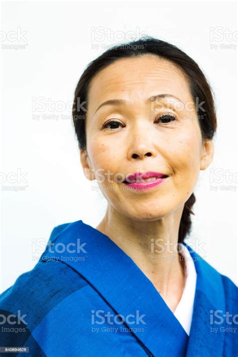 mature japanese woman portrait in blue kimono smiling kindly stock