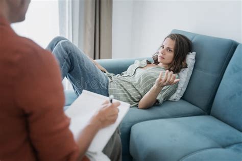 Depressed Woman Lying On Sofa During Psychotherapy Session