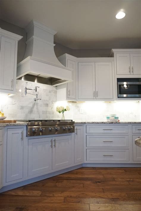 white cabinets shaker door inset cabinetry decorative range hood kitchen design trends