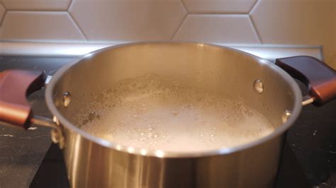 boiling water in a stainless steel pan on the kitchen stove at home