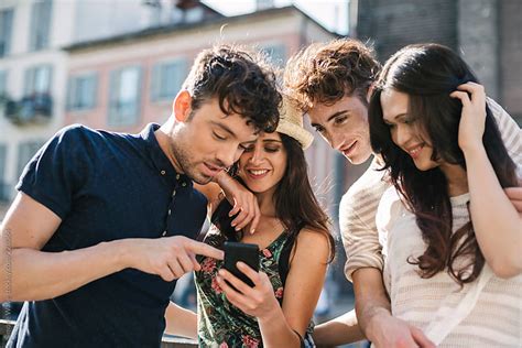group of friends using a cell phone in the city by gic lifestyle