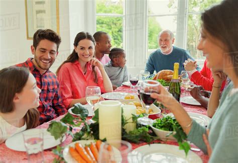 multi ethnic multi generation family enjoying christmas dinner  table
