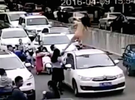 naked woman dances on top of car causing traffic jam before driver brutally yanks her down by