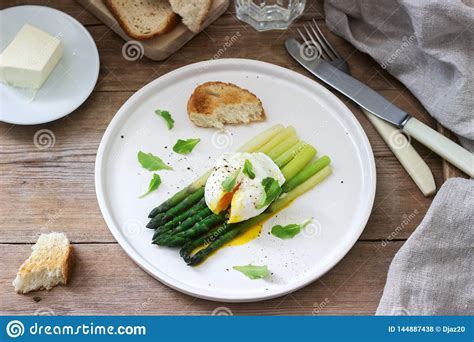 ontbijt uit gestroopt ei en gekookte asperge met boter bestaan en sla die op een houten