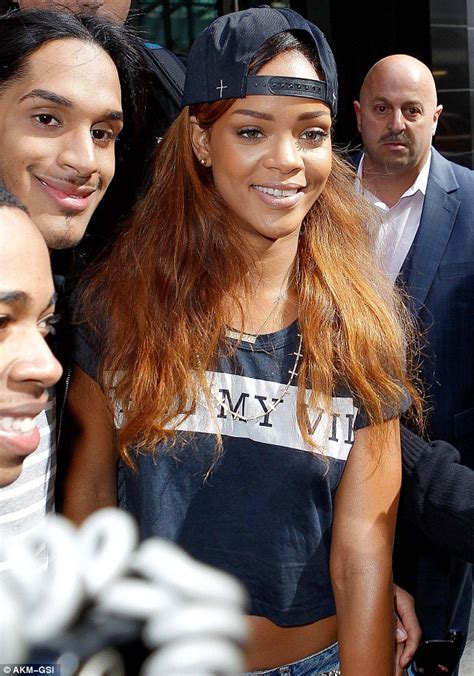 rihanna happily poses with male fans as she bares her flat tummy in a