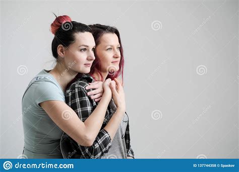 two girls hug on a white background homosexual lesbian