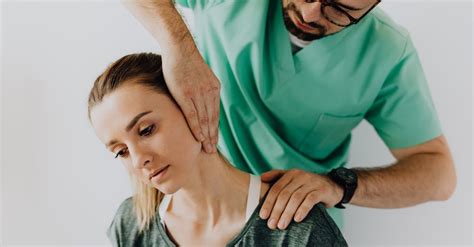 serious massage therapist rubbing female patients sore neck · free