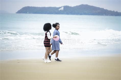 girl holding ball having fun on sandy summer beach blue sea with