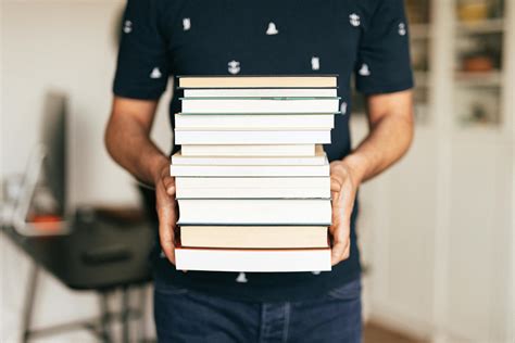person holding stack  books  stock photo
