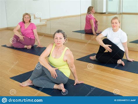 active senior women practicing twisting yoga poses stock image image