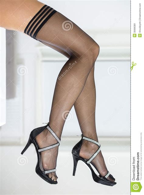 legs of a woman wearing stockings and elegant high heels stock image