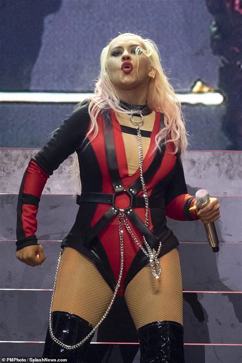 christina aguilera performs on stage in a bondage inspired ensemble