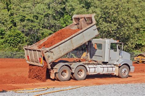 tip truck dumping dirt   construction site stock photo image