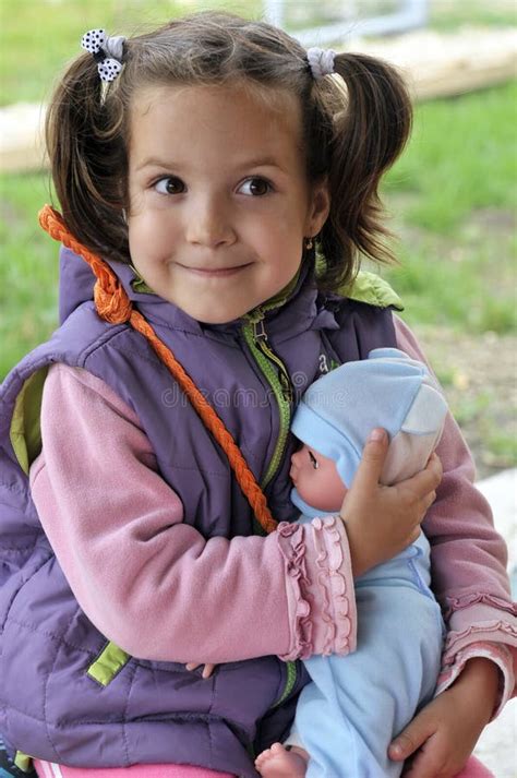 girl holding  doll stock photo image  affection