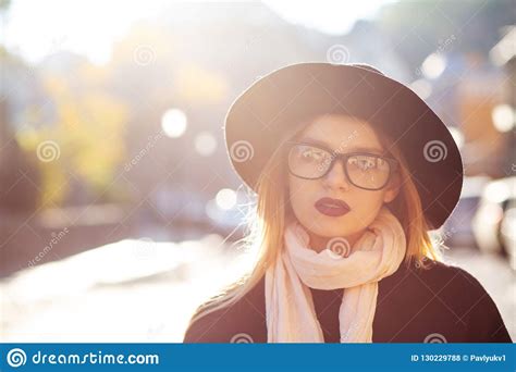 urban portrait of luxury blonde model with red lips wearing glasses and