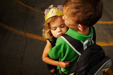 big brother gives little sister one last hug before starting his first day at kindergarten