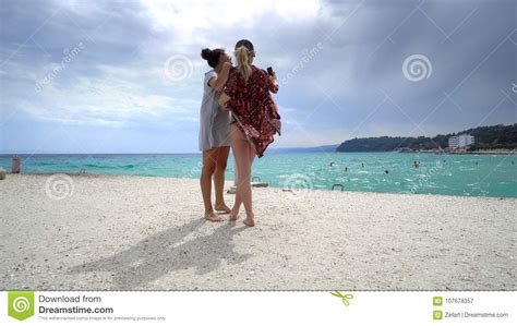Female Friends On Vacation Taking Selfies On The Beach